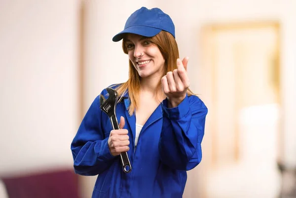 Delivery woman making money gesture on defocused background