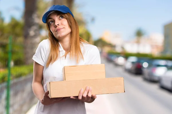 Delivery woman making unimportant gesture on unfocused background — Stock Photo, Image