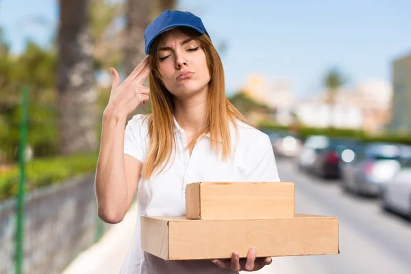 Delivery woman making suicide gesture on unfocused background — Stock Photo, Image
