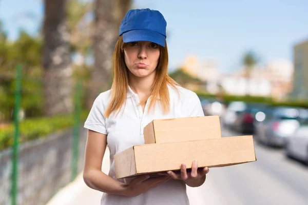 Sad delivery woman on unfocused background — Stock Photo, Image