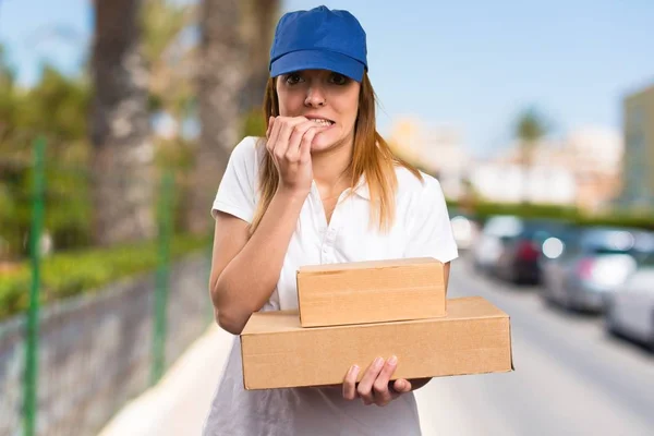 Frightened delivery woman on unfocused background — Stock Photo, Image