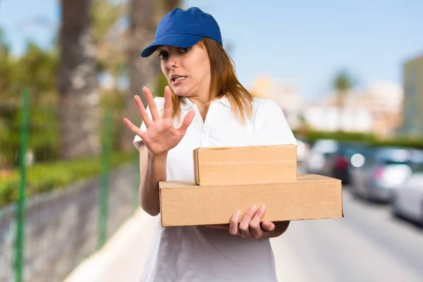 Frightened delivery woman on unfocused background — Stock Photo, Image