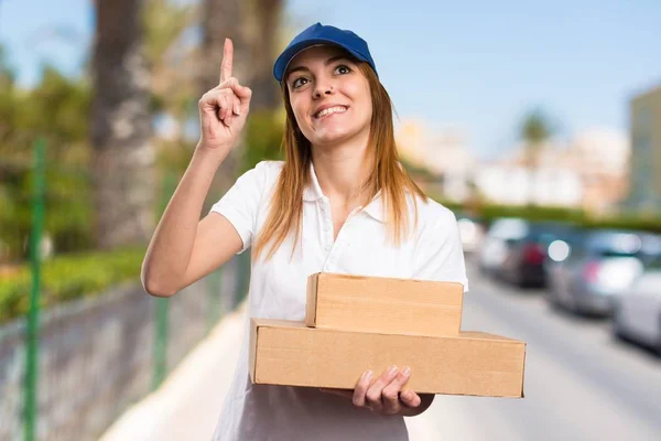 Mujer parto apuntando hacia arriba en el fondo desenfocado — Foto de Stock