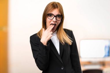 Genç iş kadını odaklanmamış arka plan üzerinde ofiste kusma jest yapma