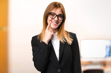 Mutlu genç iş kadını ofiste odaklanmamış arka plan üzerinde