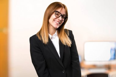 Genç iş kadını ofiste odaklanmamış arka plan üzerinde göz kırpıyor