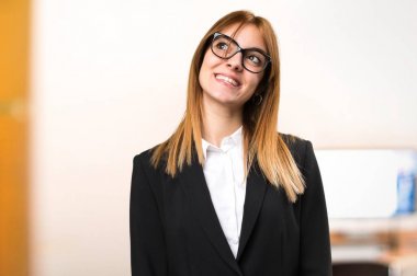 Genç iş kadını odaklanmamış arka plan üzerinde ofisinde arıyor