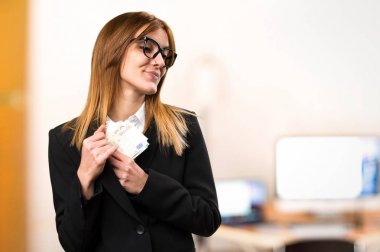 Office odaklanmamış arka plan üzerinde bir sürü para alarak genç iş kadını