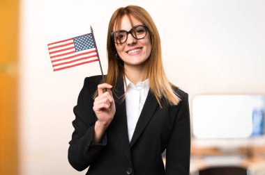 Bir Amerikan bayrağı office odaklanmamış arka planda tutan genç iş kadını