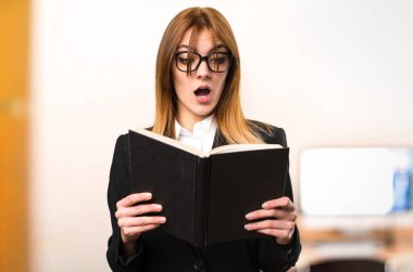 Ofiste genç iş kadını okuma kitabı odaklanmamış arka plan üzerinde