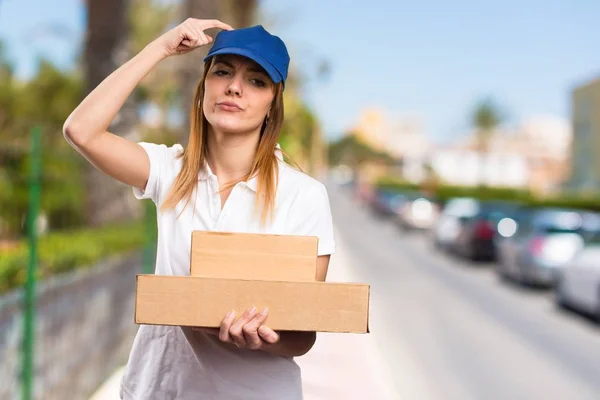 Delivery woman having doubts on unfocused background