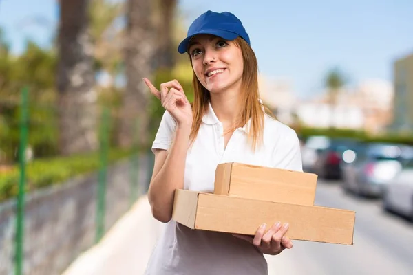 Delivery woman thinking on unfocused background — Stock Photo, Image