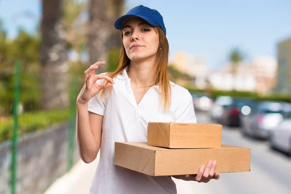 Delivery woman proud of herself on unfocused background