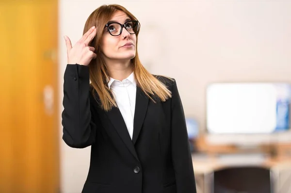 Jovem mulher de negócios fazendo gesto de suicídio no escritório em fundo desfocado — Fotografia de Stock