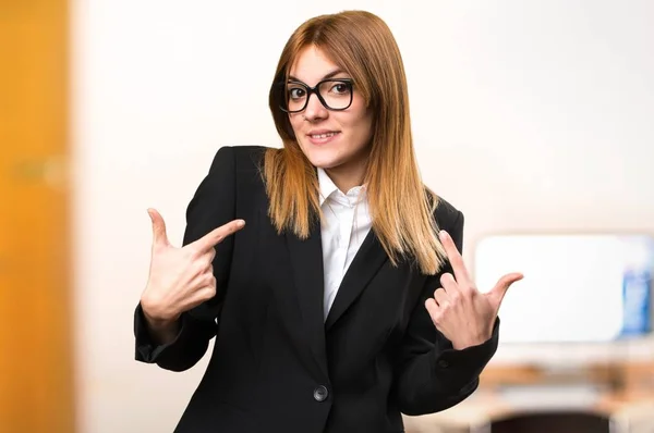 Joven mujer de negocios haciendo gesto sorpresa en la oficina en un fondo desenfocado —  Fotos de Stock