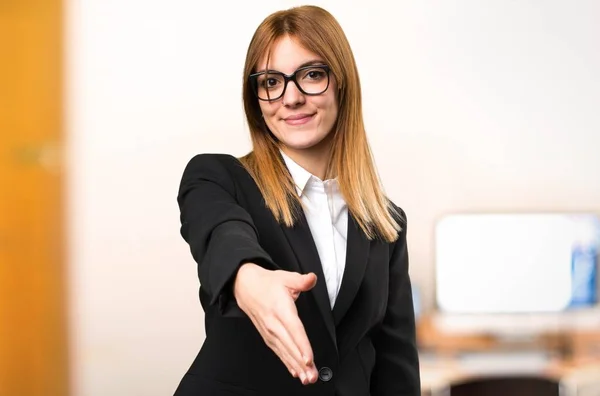 Joven mujer de negocios haciendo un trato en la oficina sobre fondo desenfocado —  Fotos de Stock