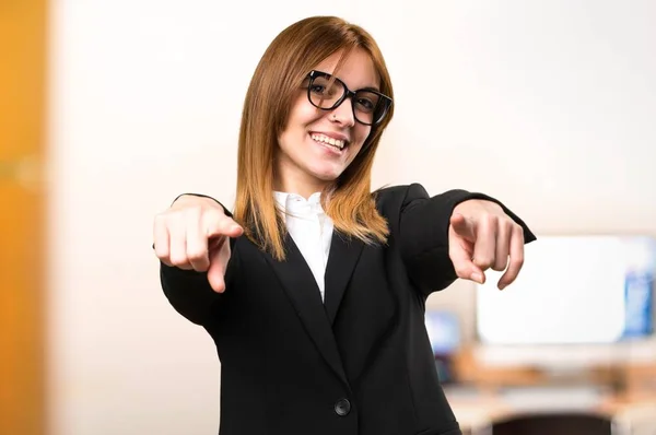 Jeune femme d'affaires pointant vers l'avant dans le bureau sur fond flou — Photo