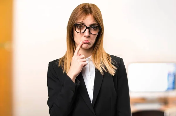 Triste jovem mulher de negócios no escritório em fundo desfocado — Fotografia de Stock