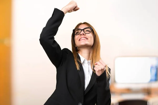 Lycklig ung affärskvinna i office på ofokuserat bakgrund — Stockfoto