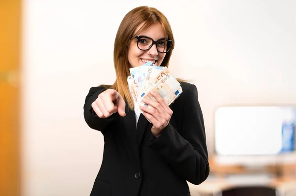 Fiatal üzleti nő vesz egy csomó pénzt a Hivatal a céltalan háttér — Stock Fotó