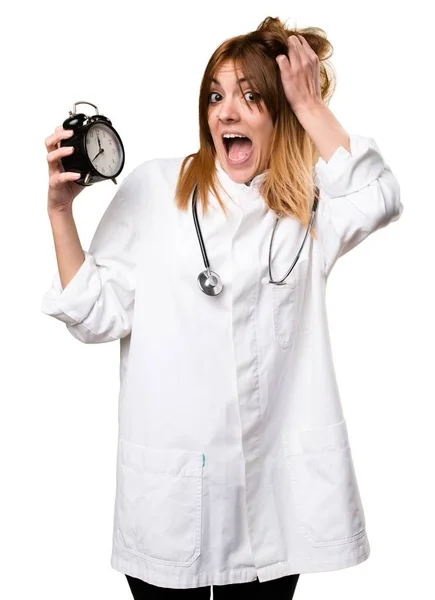 Young doctor woman holding vintage clock