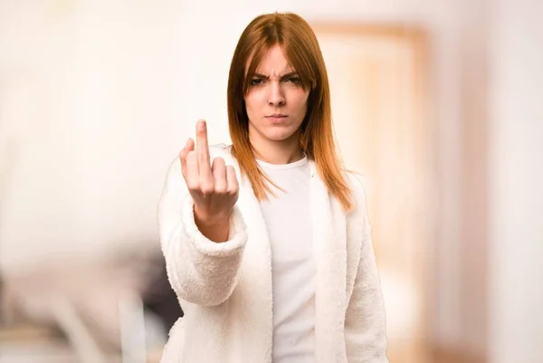 Молодая женщина в халате делает жест рога в комнате — стоковое фото