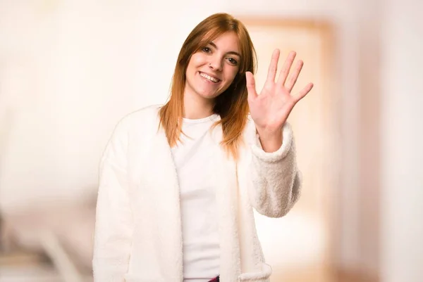 Junge Frau im Morgenmantel salutiert in einem Raum — Stockfoto