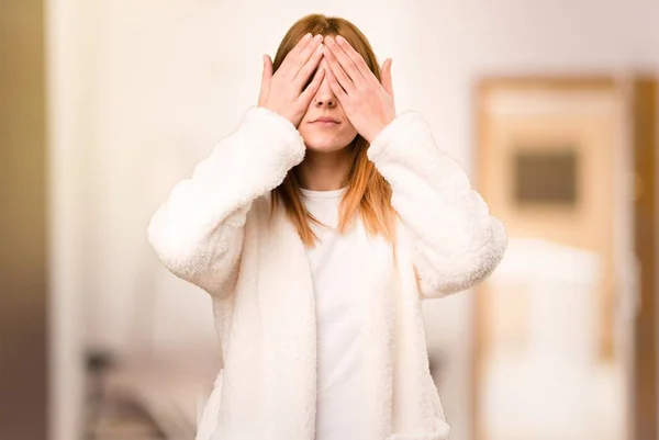 Mujer joven en bata cubriendo sus ojos dentro de una habitación —  Fotos de Stock