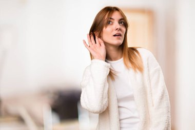 Genç kadın sabahlık bir oda içinde bir şey dinleme