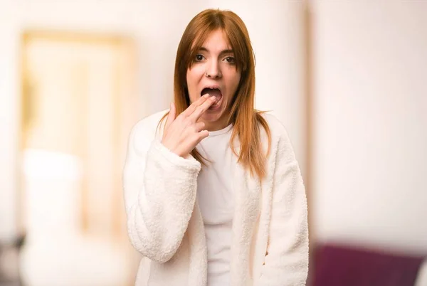 Giovane donna in vestaglia fare gesto vomito all'interno di una stanza — Foto Stock