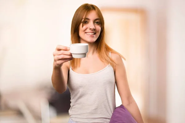 Красивая девушка в пижаме держит чашку кофе в комнате — стоковое фото