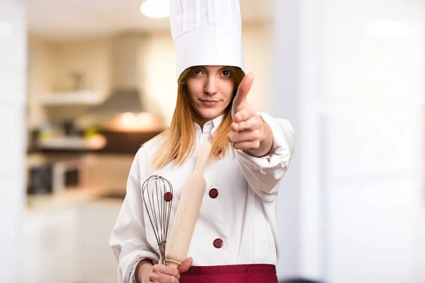 Hermosa mujer chef haciendo gesto de pistola en la cocina —  Fotos de Stock