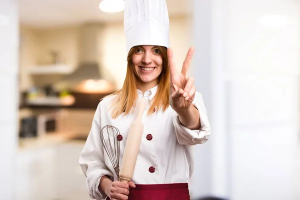 Hermosa mujer chef contando dos en la cocina —  Fotos de Stock