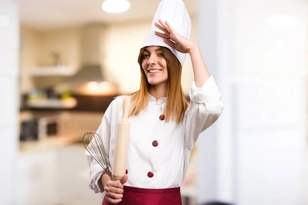 Красивая женщина-повар, салютующая на кухне — стоковое фото
