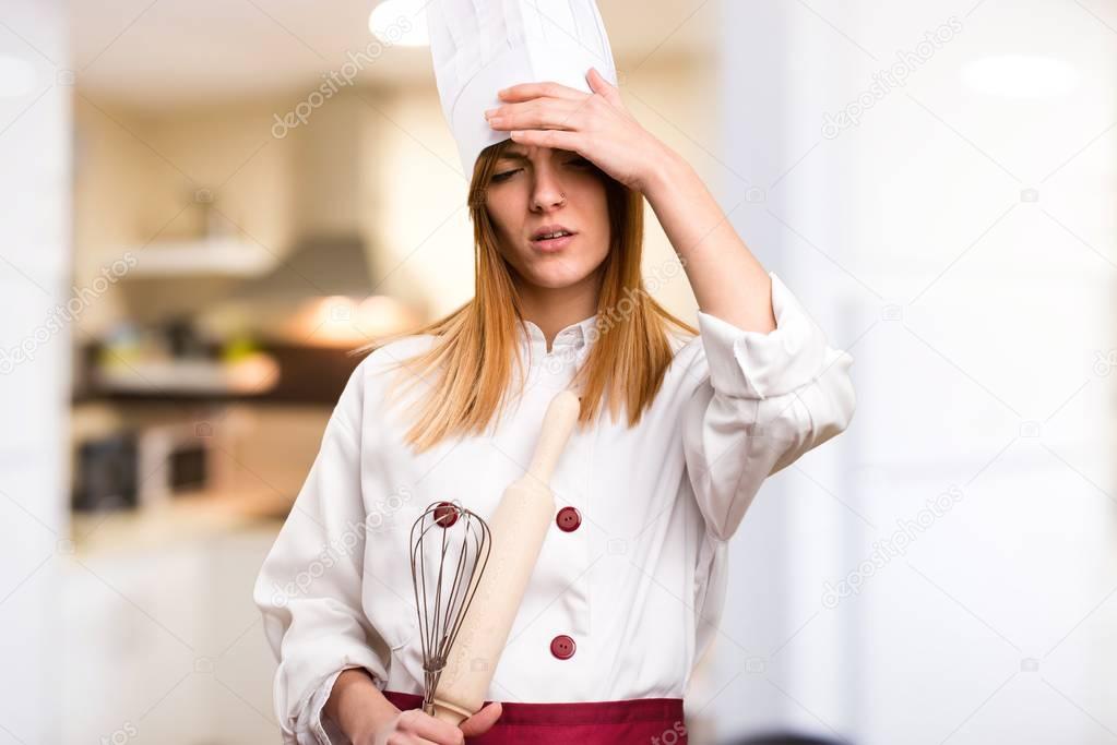 Frustrated beautiful chef woman in the kitchen