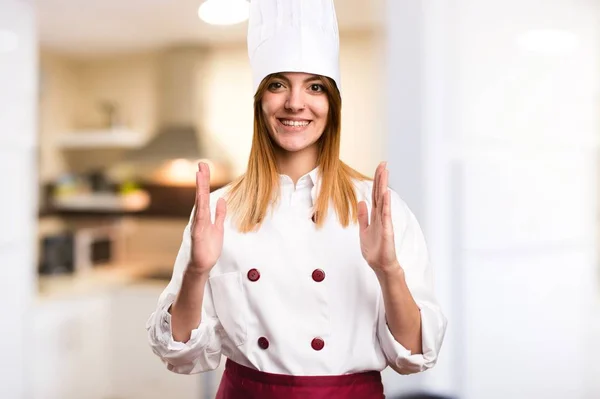 Hermosa mujer chef sosteniendo algo en la cocina —  Fotos de Stock