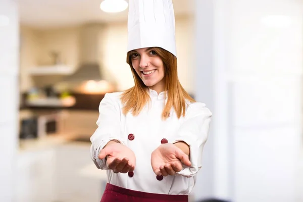 Bella chef donna che tiene qualcosa in cucina — Foto Stock