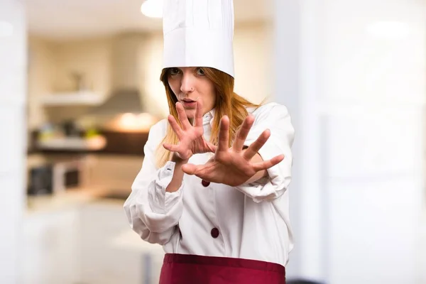 Frightened beautiful chef woman in the kitchen