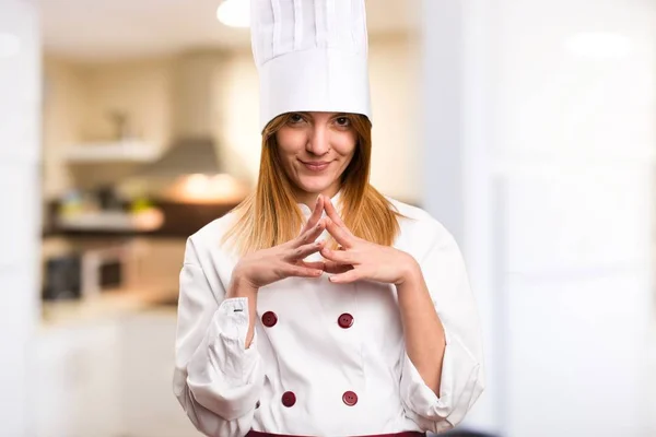 Beautiful chef woman thinking in the kitchen
