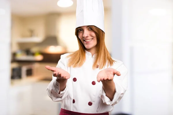 Hermosa mujer chef presentando algo en la cocina —  Fotos de Stock