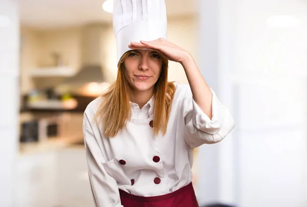 Hermosa mujer chef mostrando algo en la cocina —  Fotos de Stock
