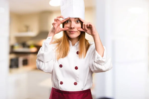 Красивая женщина-повар показывает что-то на кухне — стоковое фото
