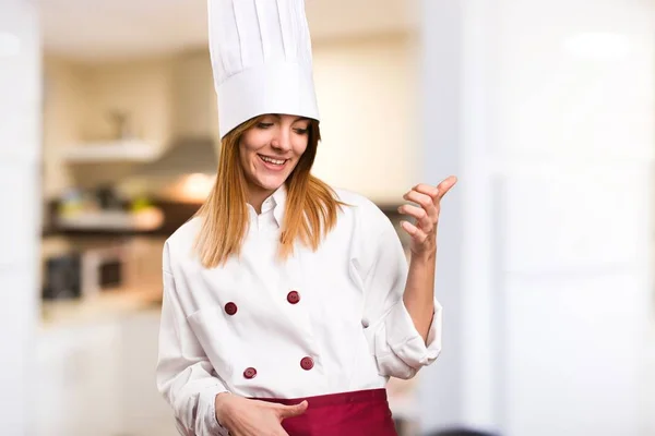 Prachtige chef-kok vrouw maken gitaar gebaar in de keuken — Stockfoto