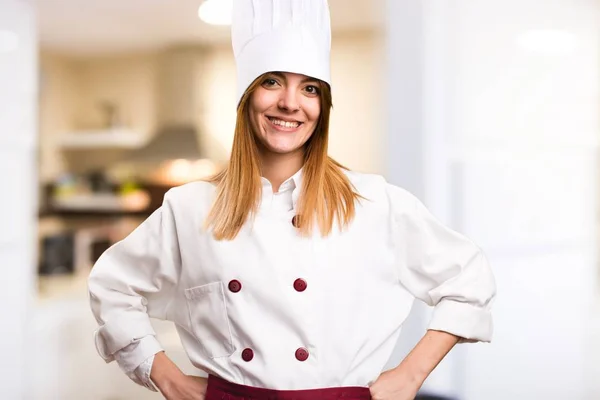 Happy beautiful chef woman in the kitchen