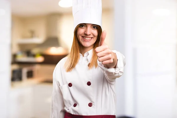 Hermosa mujer chef con el pulgar en la cocina —  Fotos de Stock