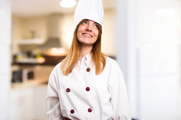 Kucharz piękną kobieta patrząc w kuchni — Zdjęcie stockowe