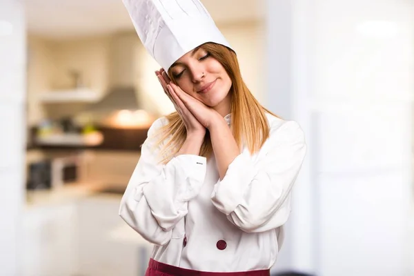 Prachtige chef-kok vrouw maken slaap gebaar in de keuken — Stockfoto