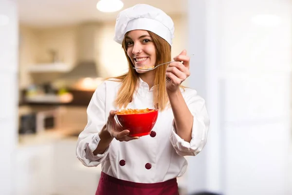 Felice Bella chef donna mangiare cereali da una ciotola in cucina — Foto Stock