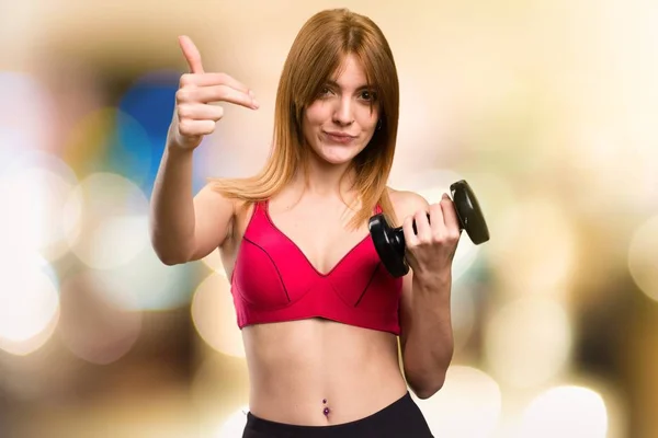 Hermosa mujer deportiva con mancuernas haciendo el gesto que viene en el fondo desenfocado — Foto de Stock