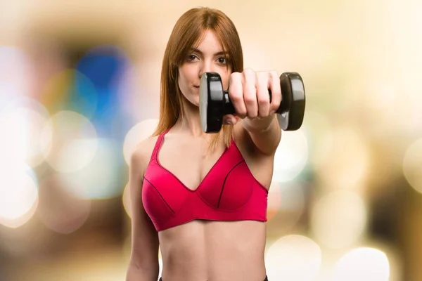 Beautiful sport woman with dumbbells on unfocused background — Stock Photo, Image